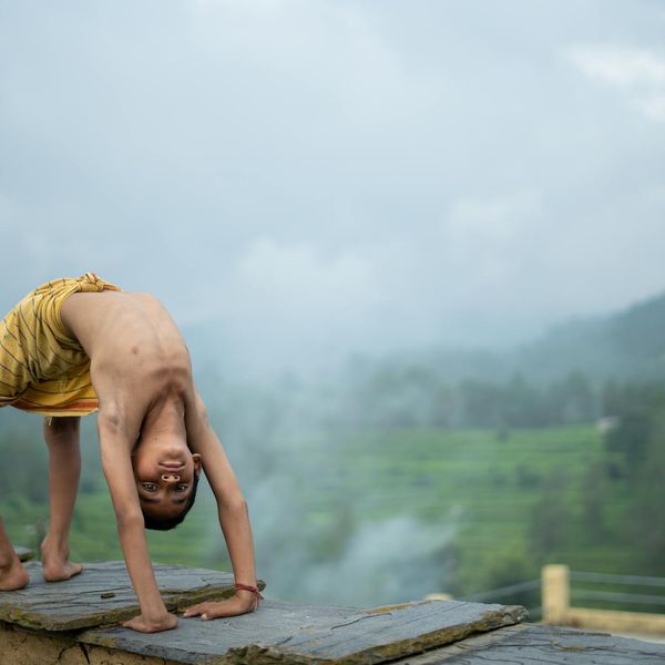 Person meditating outdoors with a serene natural background.