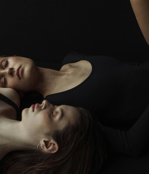 Woman in a peaceful yoga pose in a minimalist, light-filled studio.